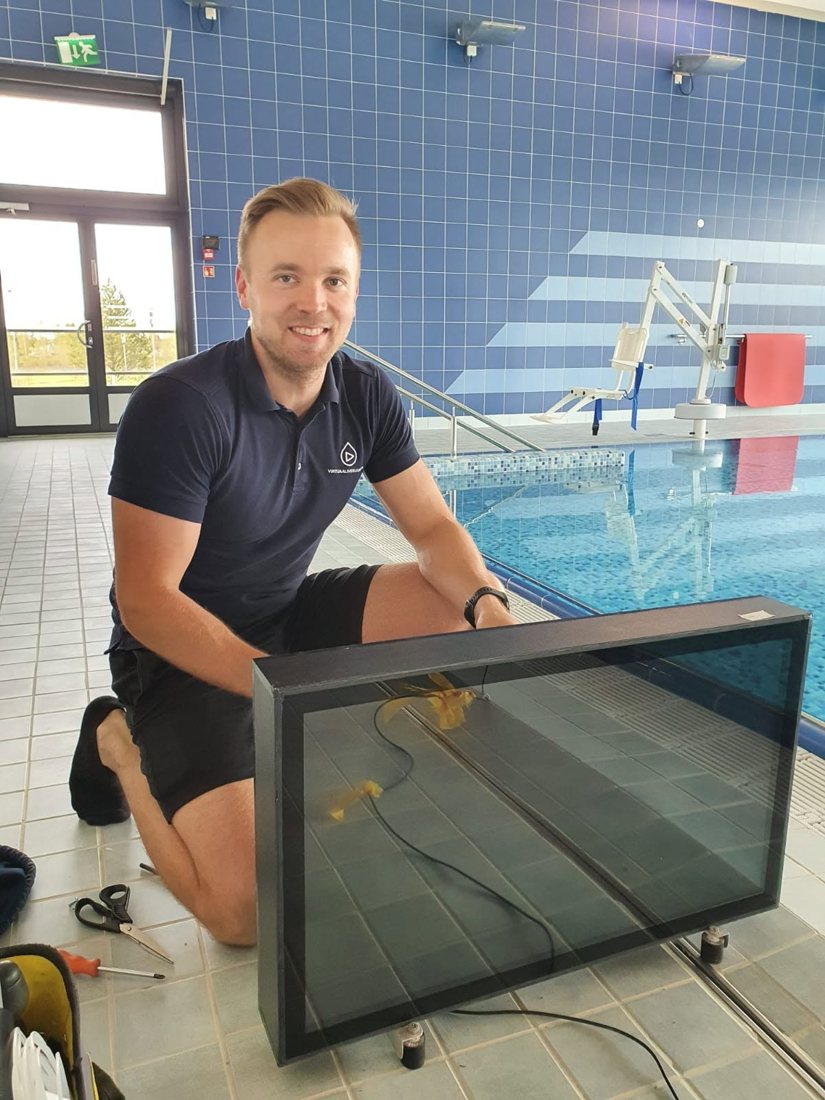 Člen týmu Waterbic s obrazovkou na okraji bazénu